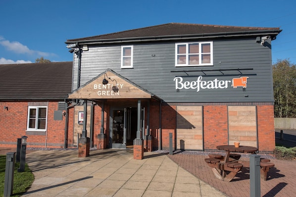 A building with a sign reading 'Bentley Green Beeffeater' and a patio area with tables and benches. - Premier Inn Walsall - M6 J10 (Walsall)