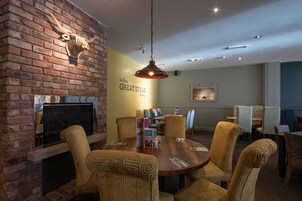 Un restaurante con pared de ladrillo, cabeza de animal montada y un letrero que dice 'GREAT STEAK'.