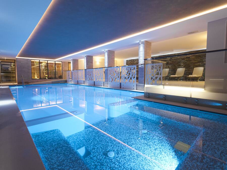 Een binnenzwembad en ligstoelen