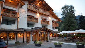 Un hôtel à thème axé sur le bien-être européen, doté de balcons en bois ornés de jardinières, d’un espace extérieur aménagé pour se détendre et d’un bar.