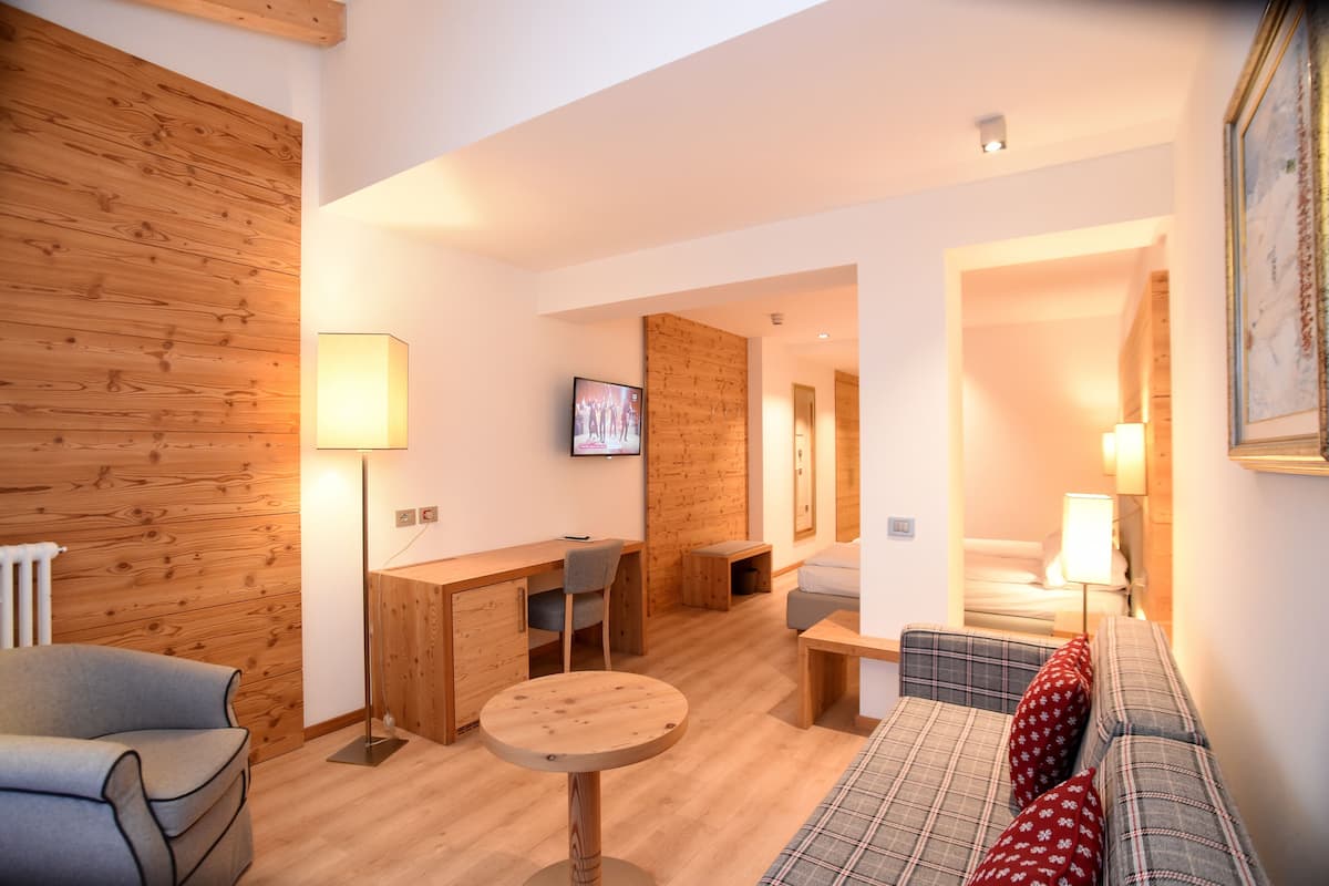 Un salon chaleureux avec un mur en bois, un canapé, une table et un téléviseur.