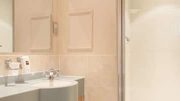 Un baño con lavamanos, espejo y ducha.