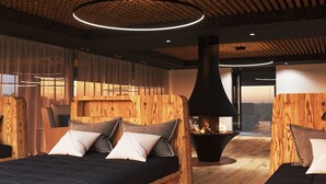 A modern bedroom with a central fireplace, wooden headboards, and a large window.