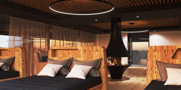 Une chambre moderne avec une cheminée centrale, des têtes de lit en bois et une grande fenêtre.
