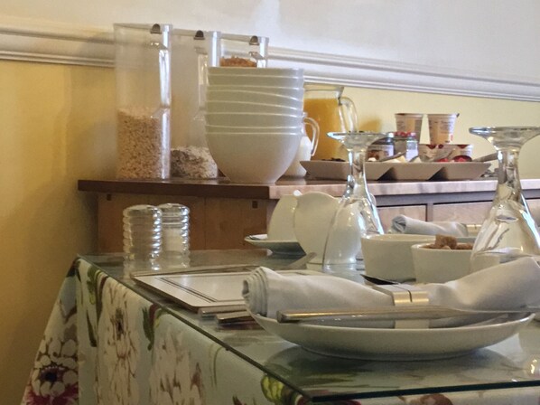A breakfast buffet setup with various dishes and containers. - The Seaham (Weymouth)