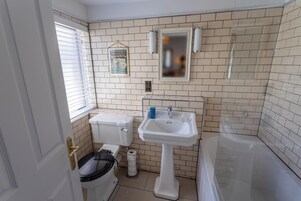 Un baño con inodoro, lavamanos y ducha.