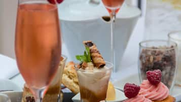 A variety of desserts and drinks on a slate board.