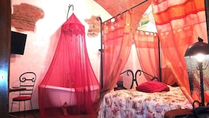A room with a bed, a chair, and a red canopy bed. - Corte dei Nobili (Lucca)