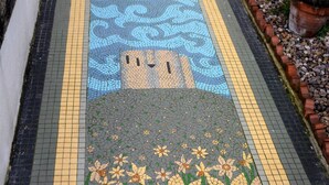 Un sendero empedrado con un estampado floral y un diseño geométrico azul.
