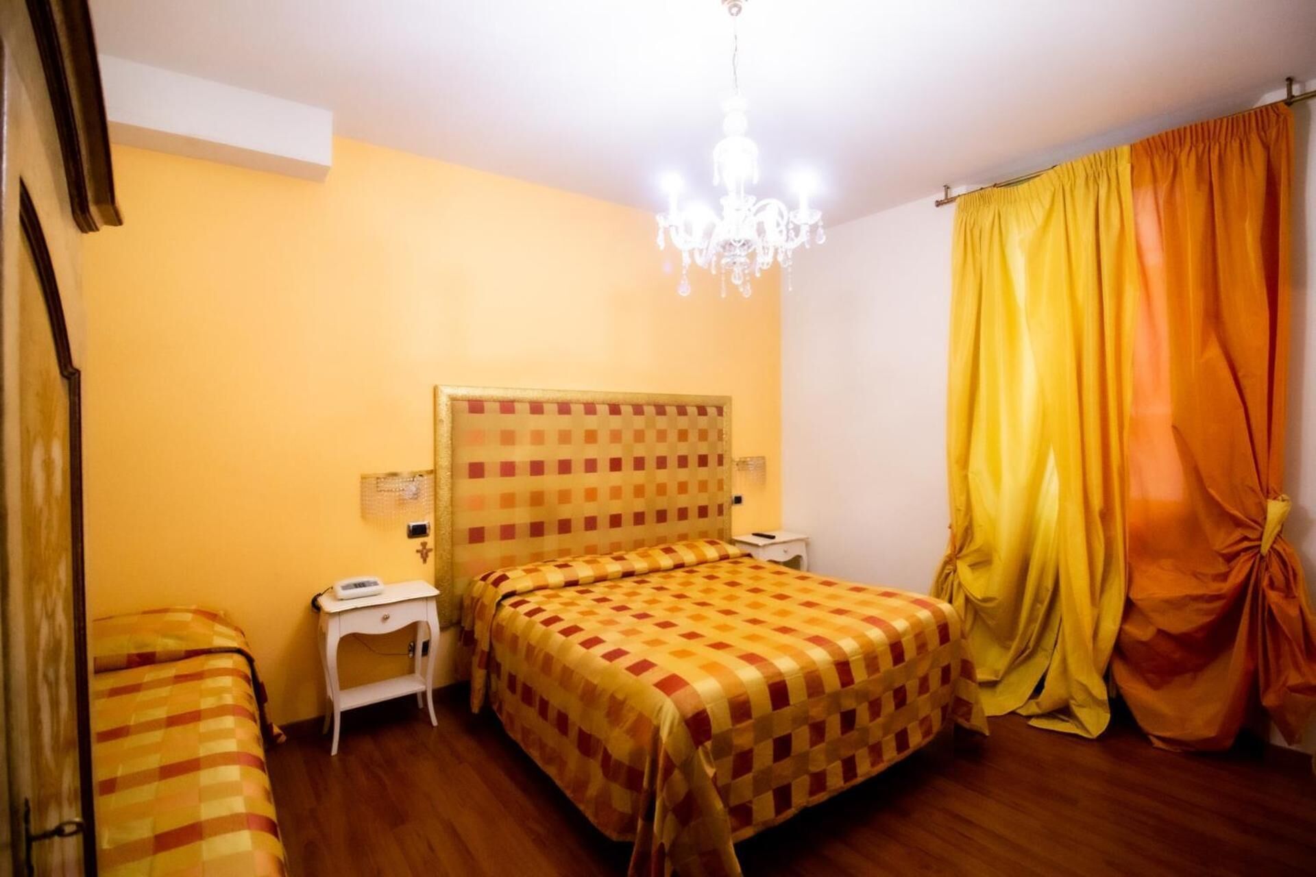 Una habitación con cama, mesita de noche y una araña.