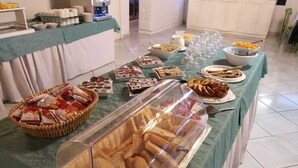 Een buffetopstelling met diverse soorten eten en een koffieapparaat.