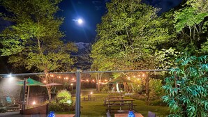 Ein möblierter Außenbereich mit Terrasse, Tischen, Stühlen und Lichterketten.