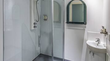 A modern bathroom with a glass-enclosed shower, a sink with a mirror, and a toilet.