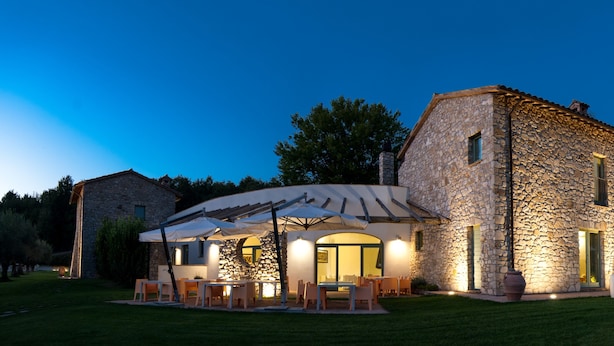 A stone building with outdoor seating and umbrellas.