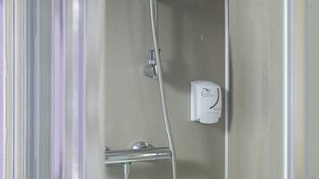 A shower with a handheld hose and a wall-mounted control panel.