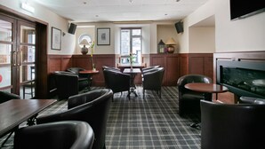 A restaurant with a checkered floor, wooden paneling, and leather chairs.
