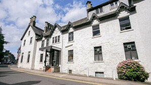 A white building with a traditional architectural style, featuring a symmetrical facade with evenly spaced windows and a central entrance.