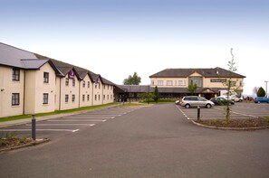 A hotel with a parking lot and a building labeled 'Premier Inn' in the background. - Premier Inn Glasgow - Motherwell (Motherwell)