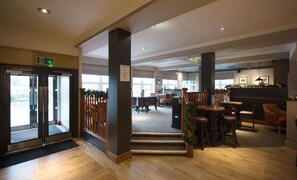 A hotel lobby with a reception desk, seating area, and a staircase leading to another level. - Premier Inn Glasgow - Motherwell (Motherwell)
