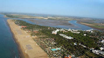 Luftaufnahme einer Küstenlandschaft mit Strand, einer Marina und Wohnhäusern.
