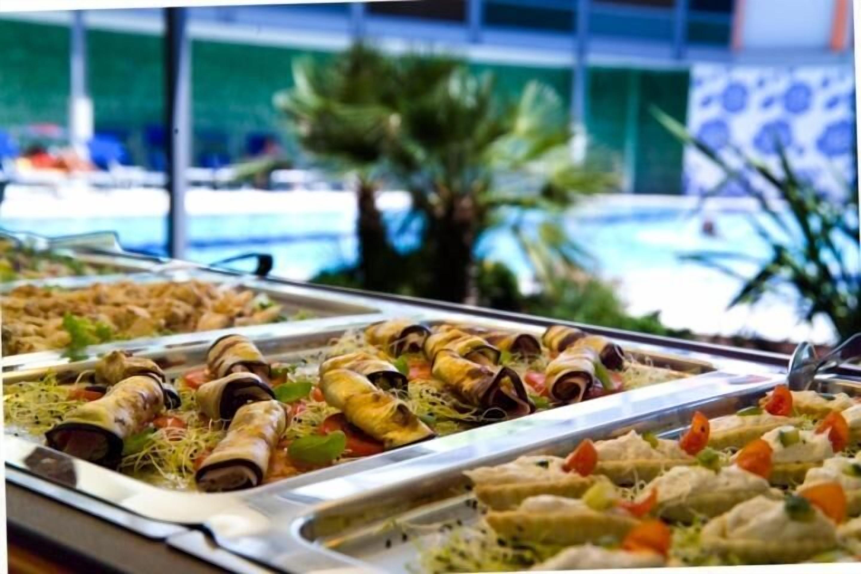 A buffet with various dishes including rolled items and appetizers.