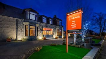 Un edificio con un cartel que dice 'Dunavon Food Pint Pillow Party' y fachada de piedra.