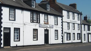A row of white buildings with black trim, including a sign for the Ecclefechan Hotel. - Ecclefechan Hotel (Lockerbie)