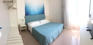A hotel room with a bed, a nightstand, a wall-mounted TV, and a window with curtains. - Hotel Principe (Caorle)