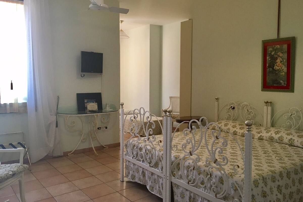 Een slaapkamer met een bed, een bureau en een stoel.