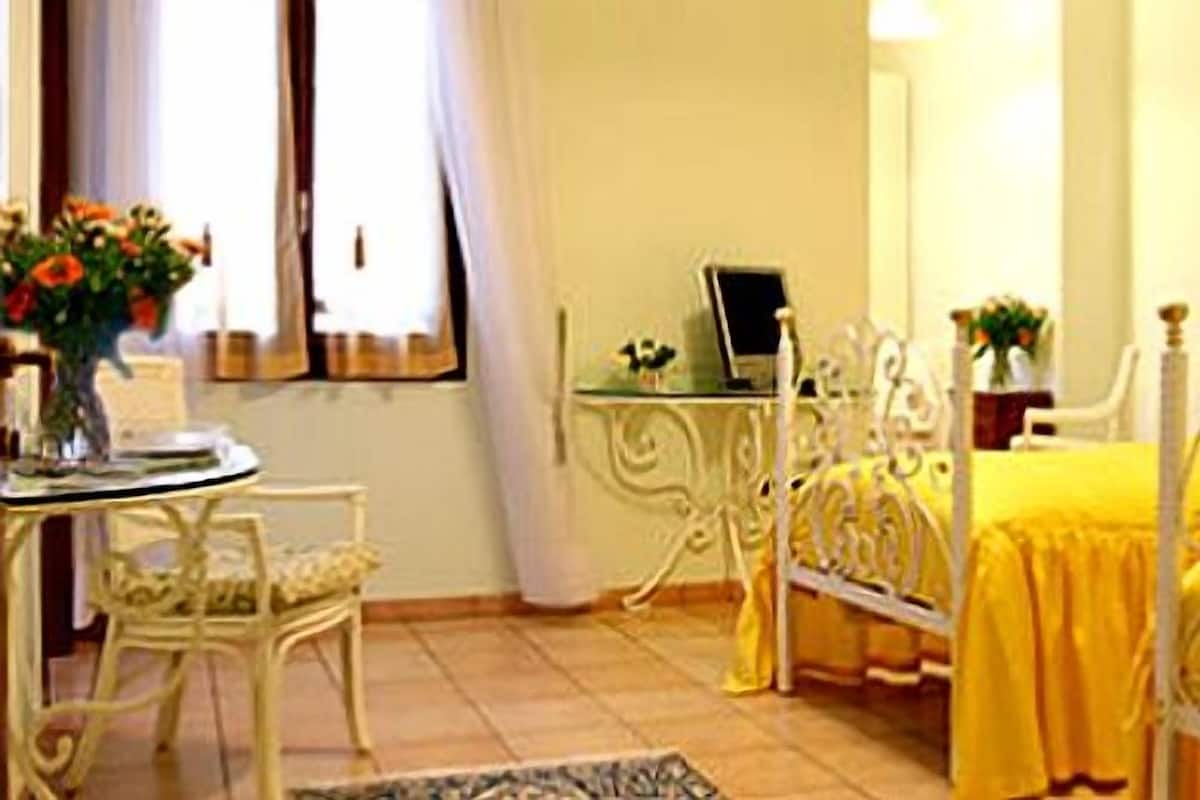 Een kamer met een bed, een bureau en een stoel.