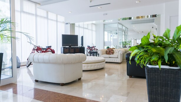 A spacious living room with a large TV, leather sofas, and a motorcycle. - Hotel Venice (Grisignano di Zocco)