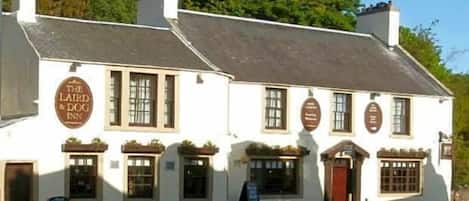Un edificio blanco tradicional con un letrero que dice 'The Laird & Dog Inn'.