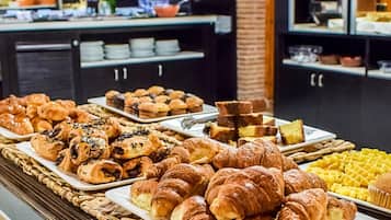 A buffet with various baked goods including croissants and muffins.