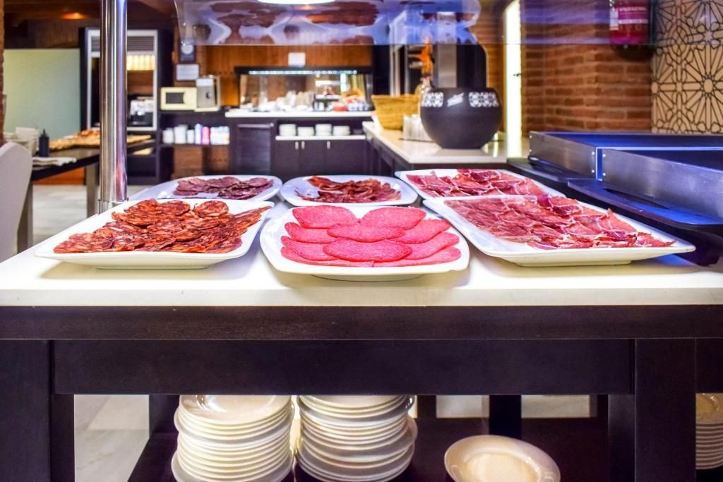 Mesa de buffet com diversos pratos de carne.