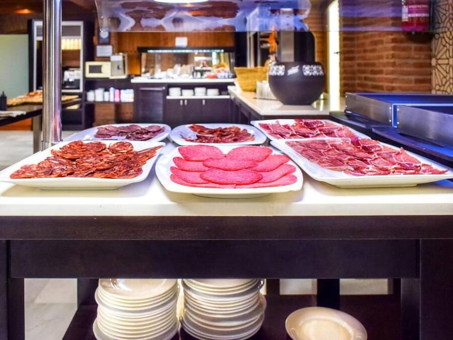 Mesa de buffet com diversos pratos de carne.