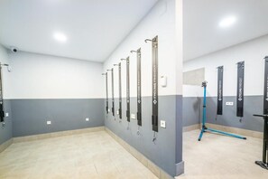 A cycling facility with multiple bike racks and a blue exercise bike. - Apartamentos Torreluz (Almeria)