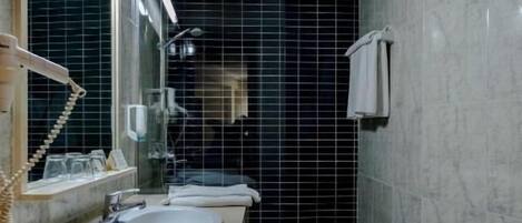 A bathroom with two sinks, a mirror, and a shower.