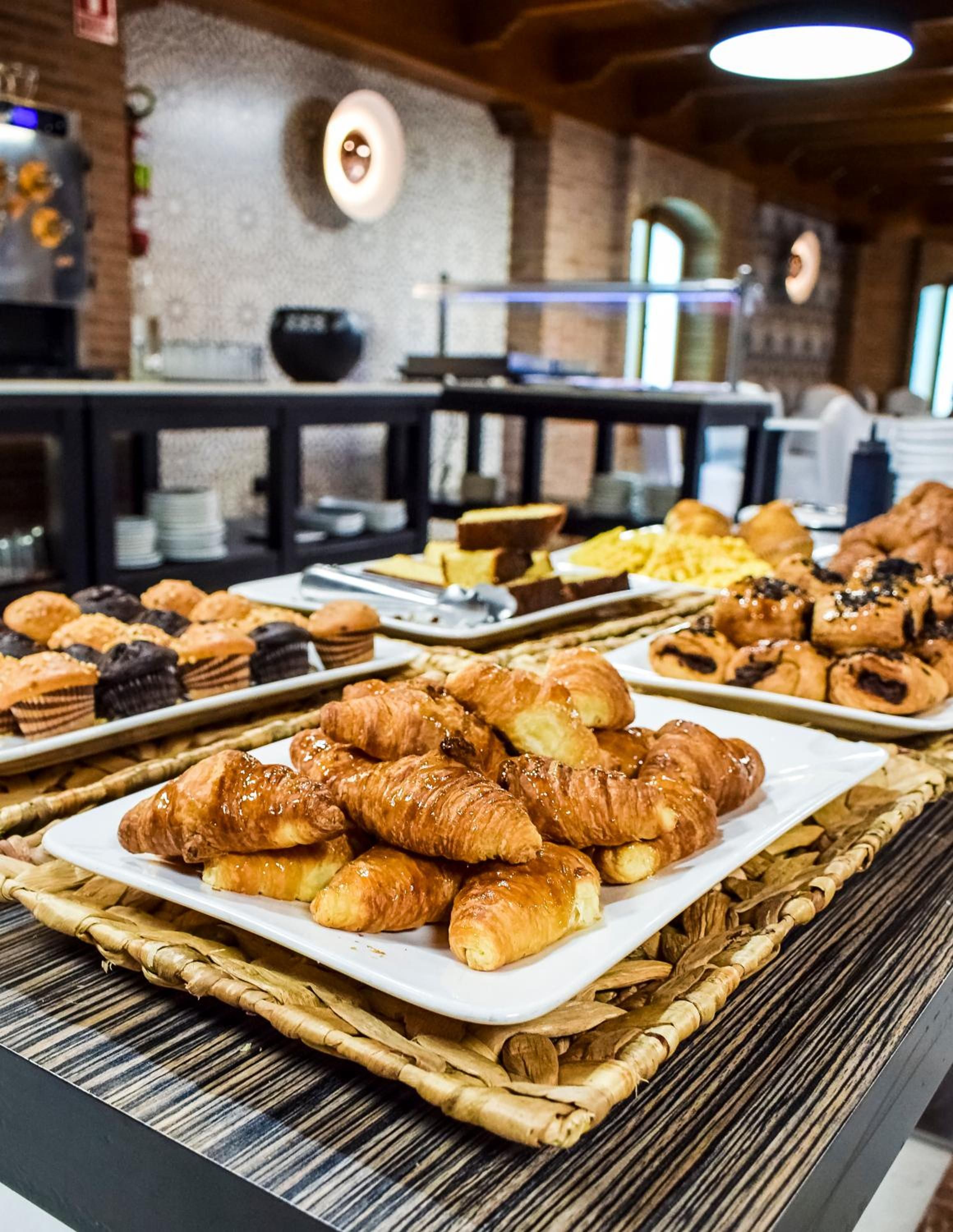 A buffet with various baked goods including croissants and pastries.