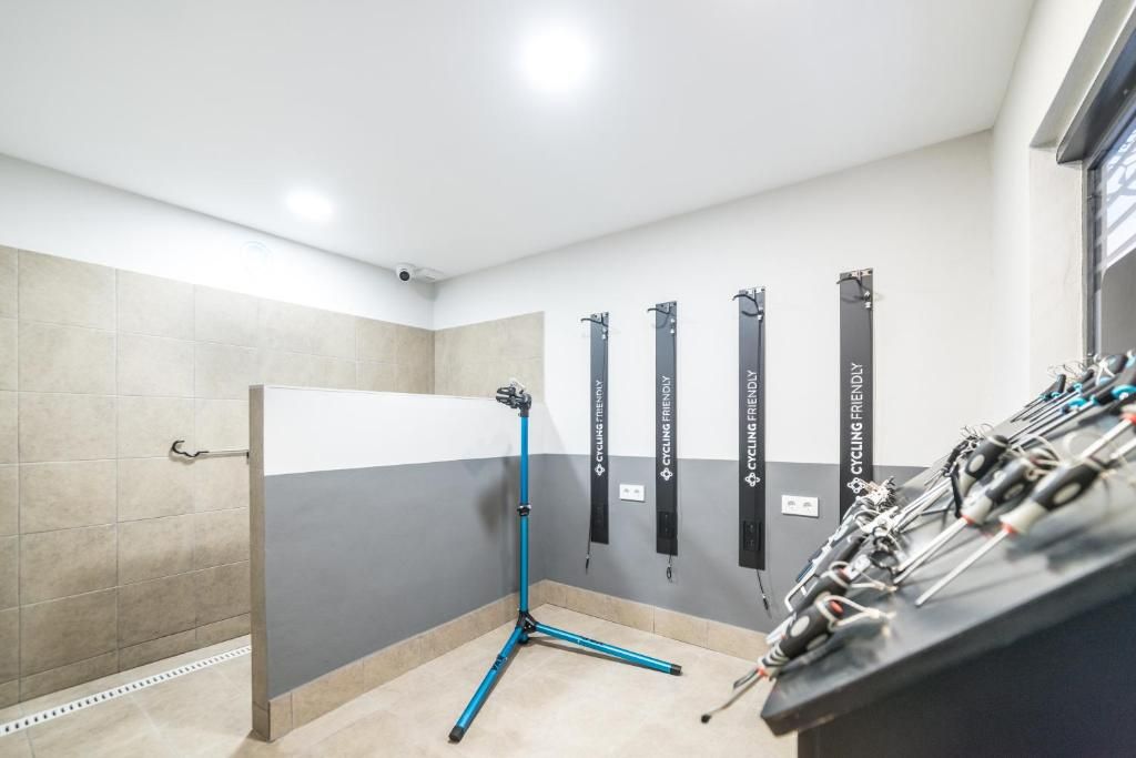 Una habitación con una estación de equipo de ciclismo, un soporte para bicicletas en la pared y suelo de baldosas.