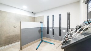 Una habitación con una estación de equipo de ciclismo, un soporte para bicicletas en la pared y suelo de baldosas.