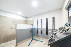 A room with a cycling equipment station, a wall-mounted bike rack, and a tiled floor. - Apartamentos Torreluz (Almeria)