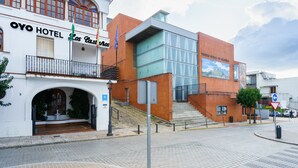 Un hotel con una fachada moderna, una entrada visible y una escalera que conduce a ella.