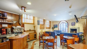 Un restaurante con bar, comedor y chimenea.