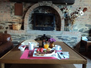 A breakfast table with a plate of food, a coffee cup, and a bottle of olive oil.