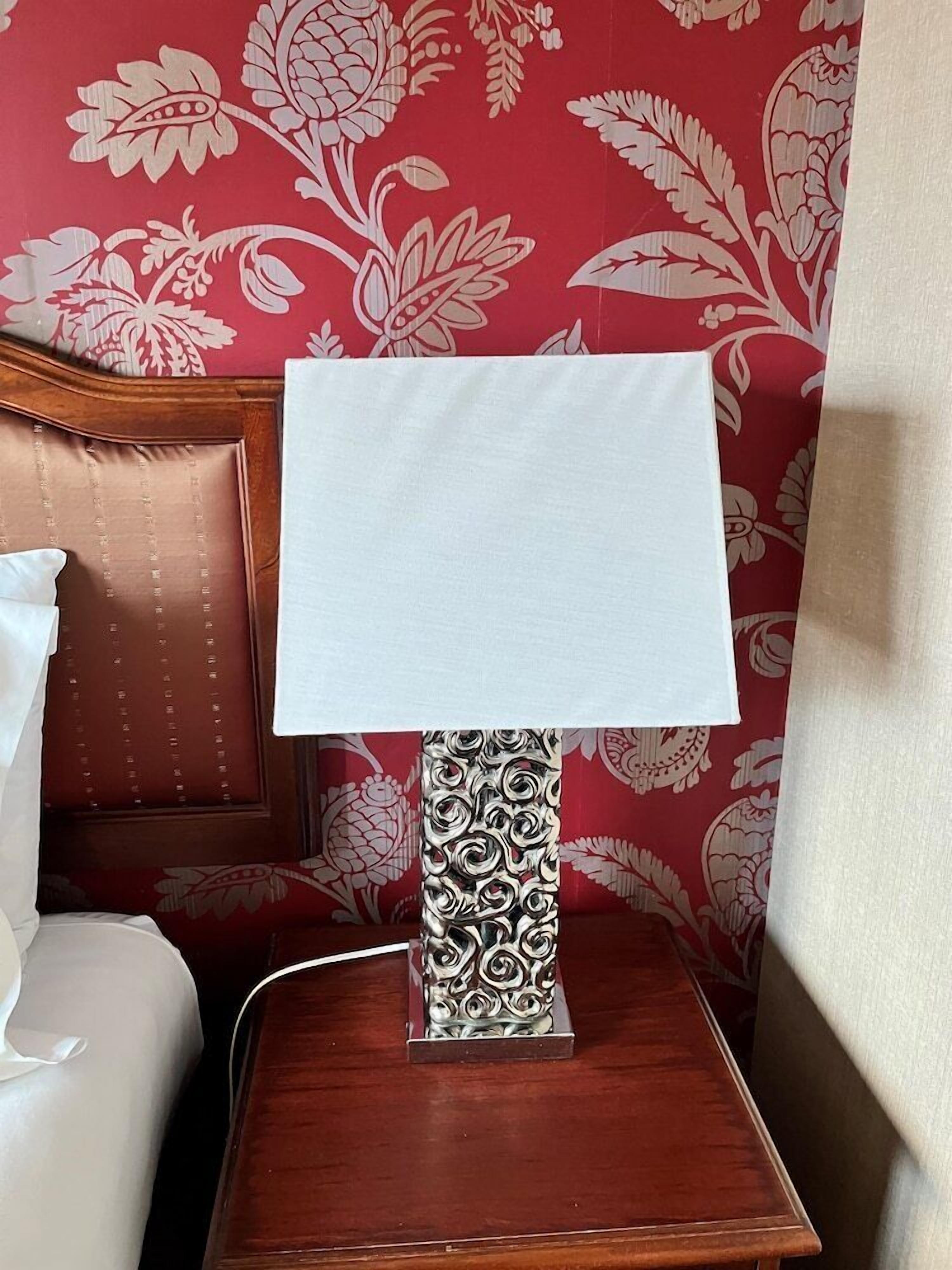 A neatly made bed with a white comforter and a wooden headboard.