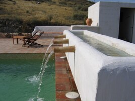 Una piscina al aire libre, sombrillas, tumbonas