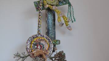 En dekorativ väggdekoration med ett hängande ornament, en liten kruka och en kanna.