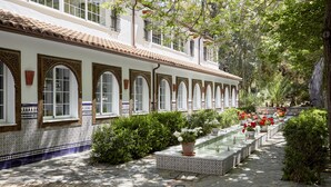 A courtyard with a tiled floor, a water feature, and potted plants.