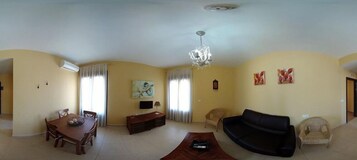 Una sala de estar con una mesa de comedor, sofá y una araña.