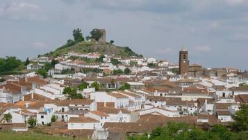 A densely packed town with white buildings and a prominent church tower on a hill.